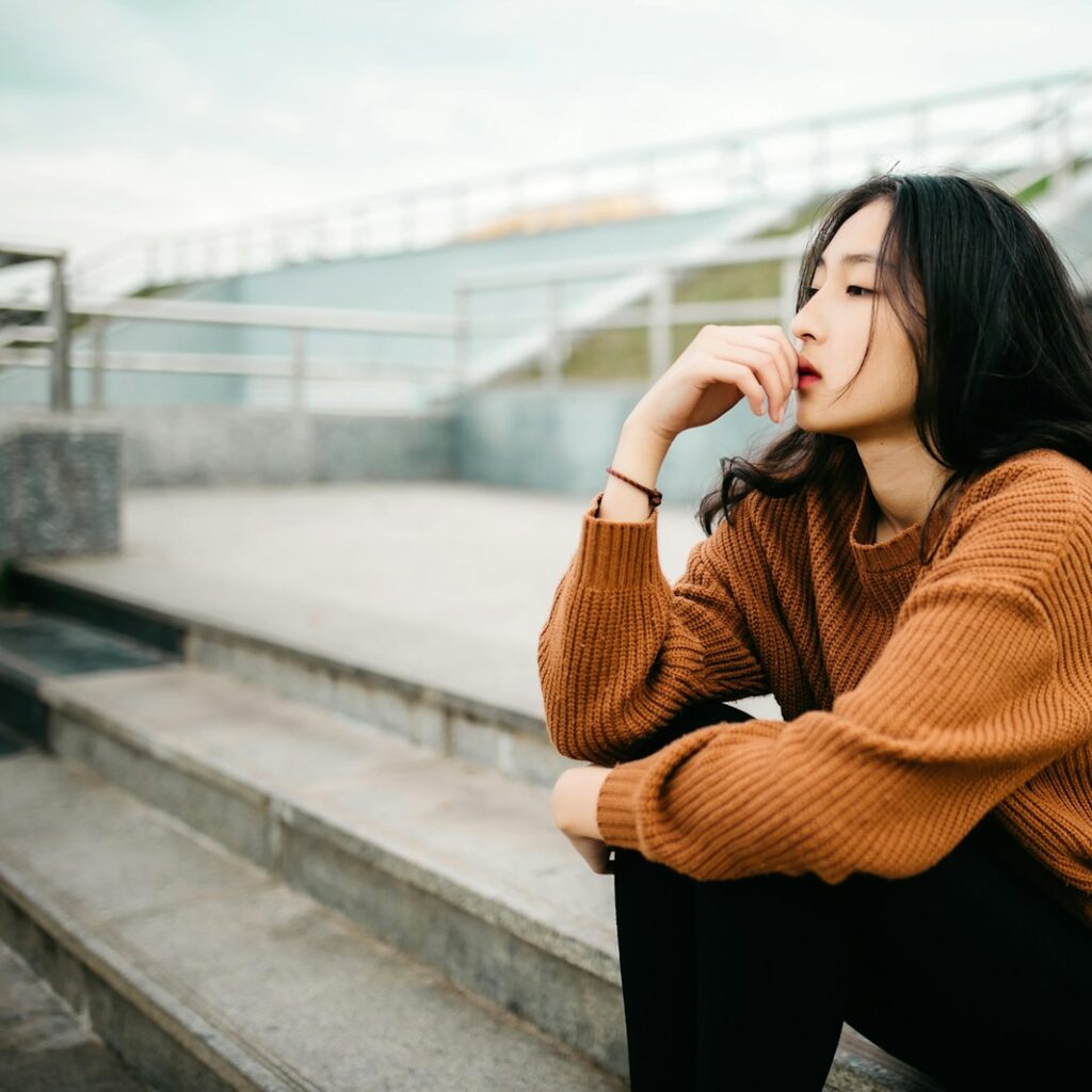 woman wearing brown sweater holding lips