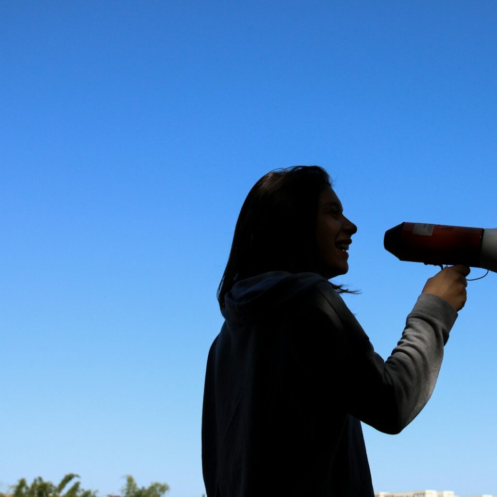 man in black hoodie drinking from a bottle