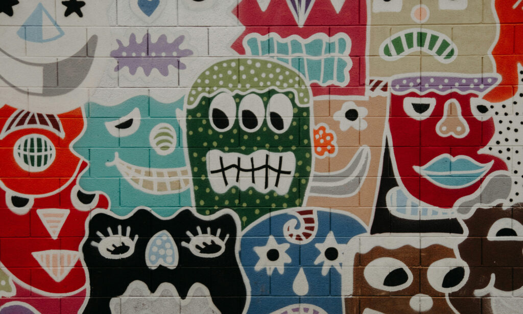 Fotografía de un mural con diferentes tipos de expresiones faciales demostrando diferentes emocionales, utlizada para el material didáctico sobre la educación emocional como recurso básico para ayudar a los jóvenes a navegar momentos de incertidumbre, presión o intensidad emocional