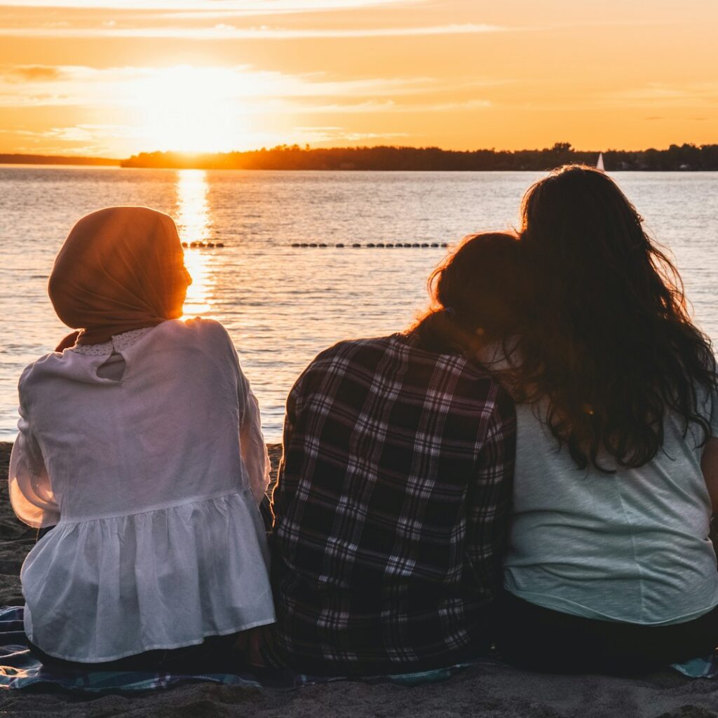 people sitting in front of body of water during daytime